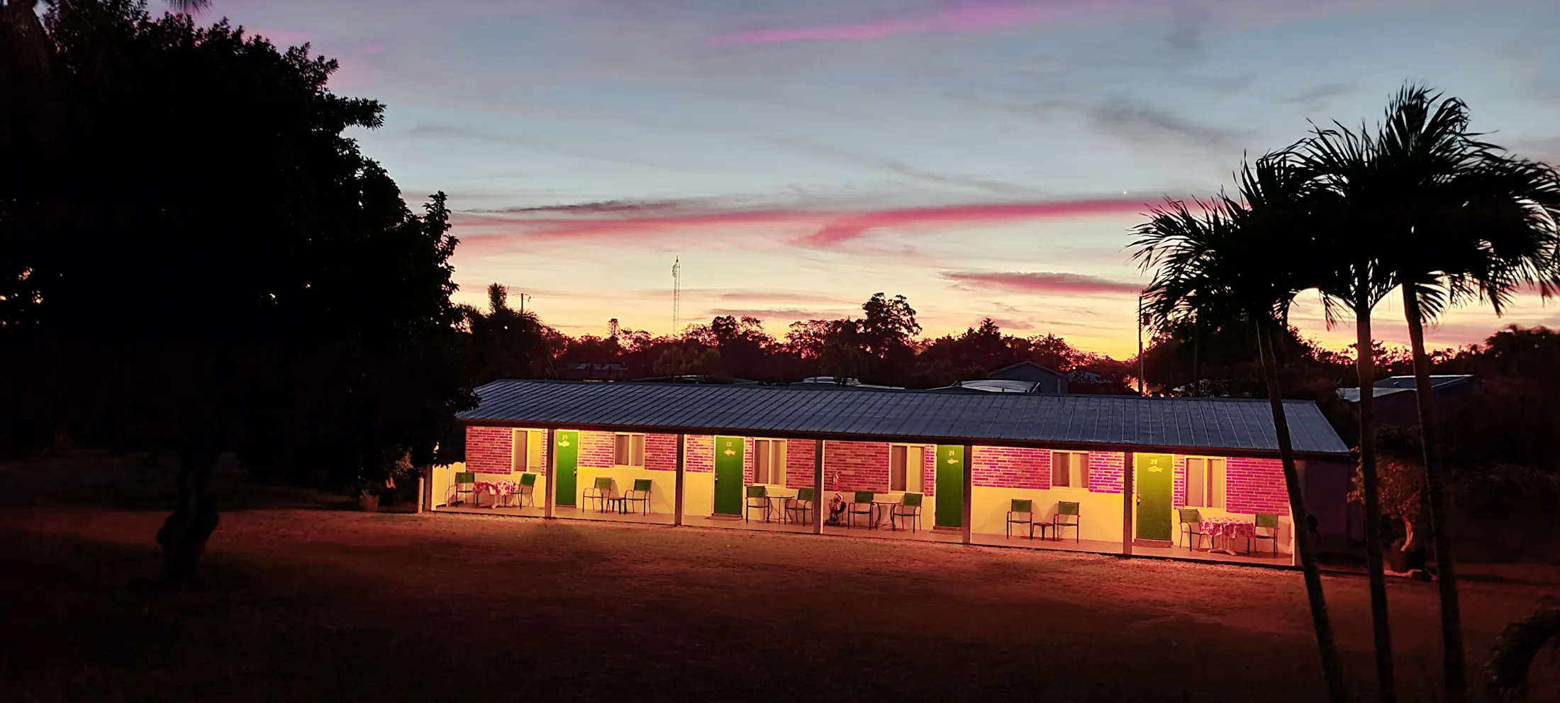 The Parkway motel building at sunset under palm silhouettes