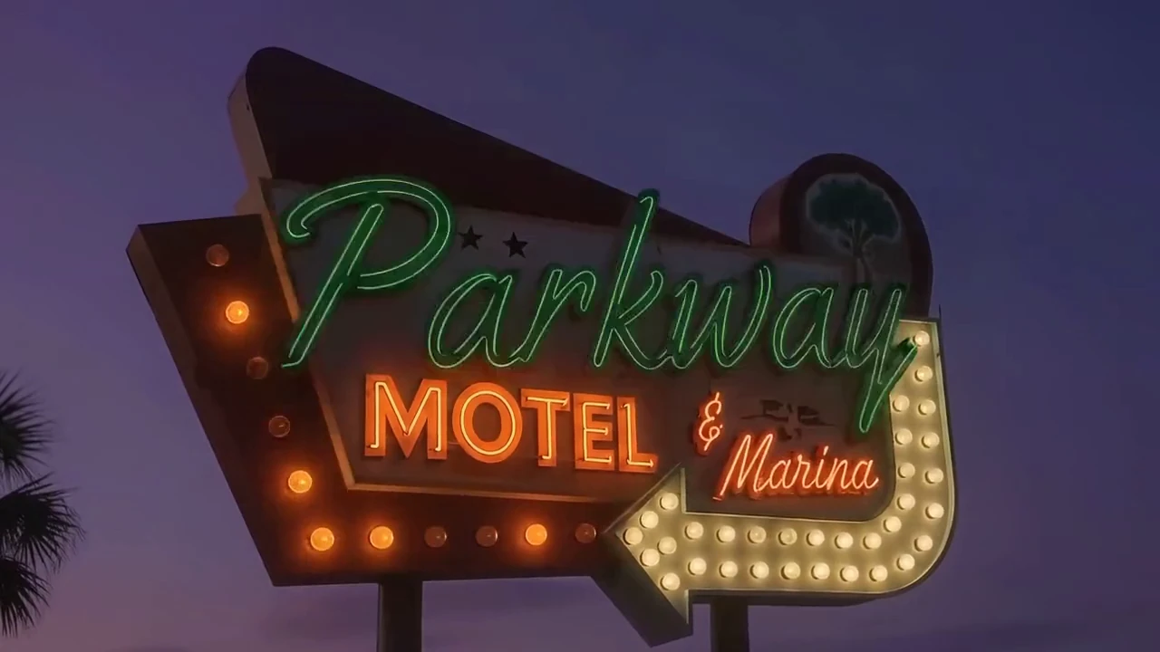 The Parkway Motel & Marina neon sign glowing against a purple dusk sky